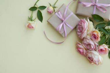 Sevgililer Günü tasarım geçmişi açık pembe güller ve bej arka planda paketlenmiş Kraft hediye kutusu. Çiçek kartı. Tatil, tebrikler, anneler günün kutlu olsun. Uluslararası Kadınlar Günü.