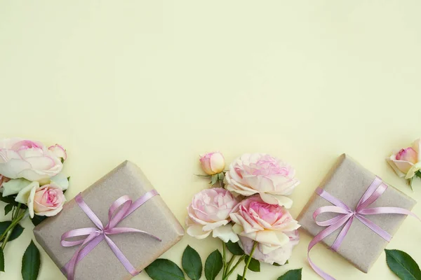 Composition of flowers. Gifts and pink flowers for pastel background. Women's Day. Flat lay, top view, place for text copy space. Flower card. Holiday, congratulations,  mothers day, Women's day.