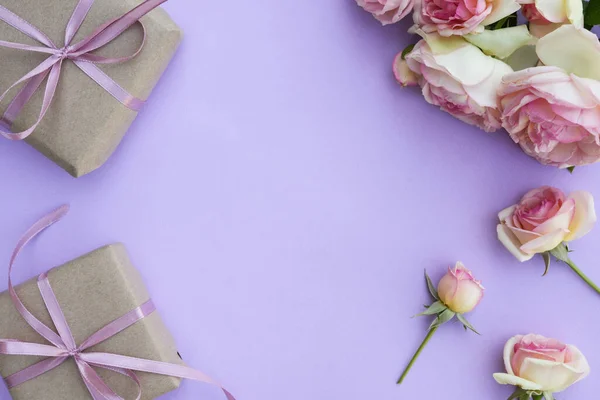 Blumengestell Mit Rosenblüten Blütenblättern Und Geschenkschachteln Auf Violettem Hintergrund Flache lizenzfreie Stockfotos