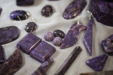 Pamuk kumaş üzerindeki Charoite mücevher düzeni.