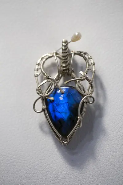 Fantastik gümüş çerçeveli eşsiz labradorit beyaz deriye yapışmış..