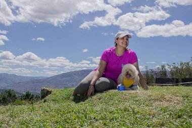 Latin esmer kadın, kaniş köpeğiyle birlikte doğanın yanında güneşli bir günün tadını çıkarıyor. Hayvanlarla hafta sonu, hayvanlarla aşk..
