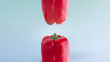 Mavi arka plan kompozisyonu üzerinde kırmızı çan akranı. Kırmızı dolma biberin üstü ve altı yan görünümü 