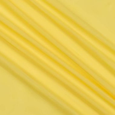 Yumuşak sarı ipeksi kumaş. Aşk, tekstil, güzellik ve moda.