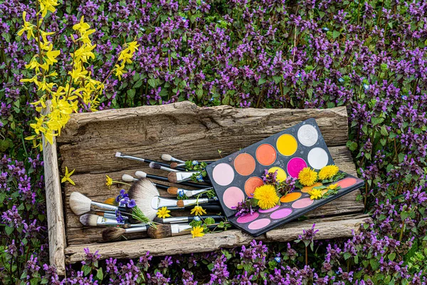 Göz farı paleti. Makyaj fırçası hazır. Klasik ahşap kutu. Çiçek tarlası. Forsythia.