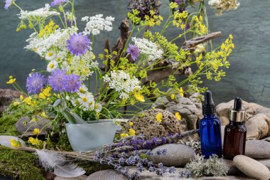 Ekolojik buket, mavi pipet şişesi, kahverengi pipet şişesi, farmakolojik havan, yabani çiçekler, buket, kuş tüyü, nehir taşları, durgun hayat.