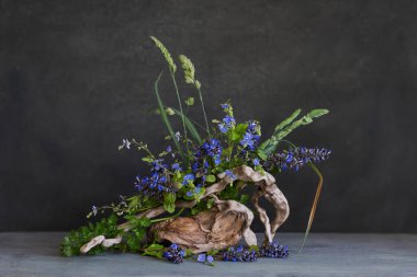 İlkbahar kır çiçeklerinin ağaç kütüğündeki doğal bir kompozisyon.