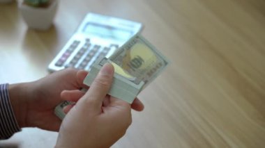 Yatırım için para say. İşadamı iş planlar, faiz oranları, vergiler, gelir, giderler, sermaye hesaplar.