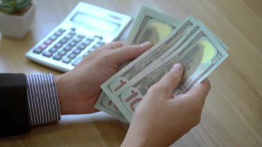 Yatırım için para say. İşadamı iş planlar, faiz oranları, vergiler, gelir, giderler, sermaye hesaplar.