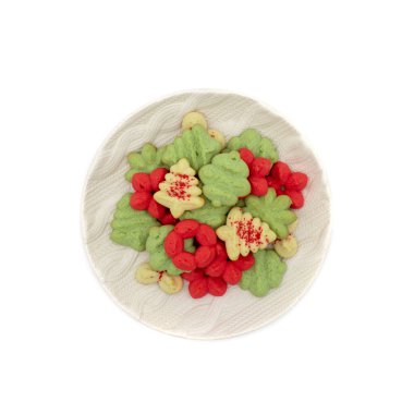 Kırmızı, yeşil ve beyaz renkli noel kurabiyeleriyle dolu yuvarlak tepsi. Ağaç, süs ve çiçek şekillerinde kırmızı kumlama şekeri.