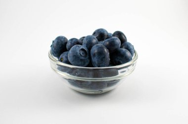 Yaban mersinlerinin küçük bir cam kasede çekilmiş fotoğraflarını kapat.