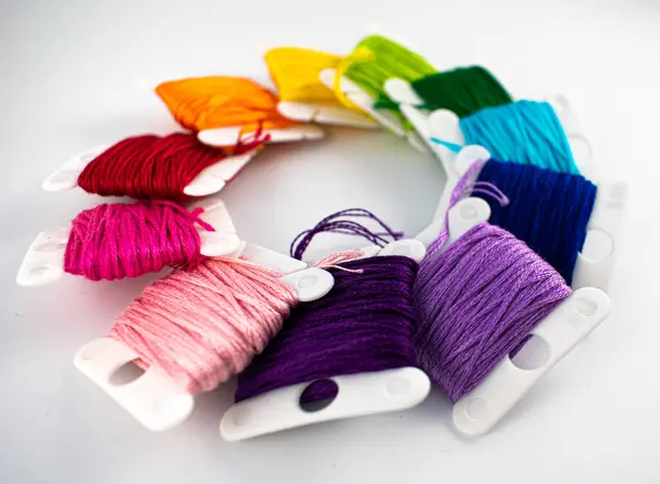 Photograph showing a ring of rainbow embroidery thread on bobbins