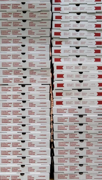 Stack of red and white pizza boxes at a restaurant