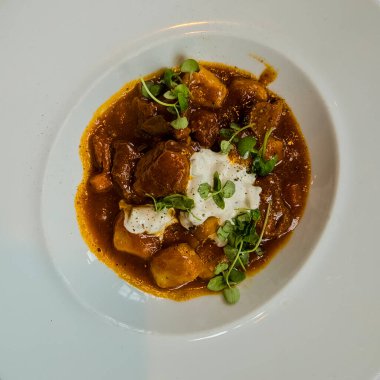 Bir parça kremalı haşlanmış biftek ve gnocchi. 