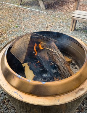 Odunlar ve odun külleri olan kırsal bakır ateş çukuru.