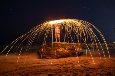 Adam ateşi yavaş çekimde döndürür.