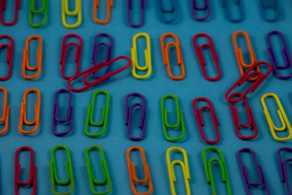 multi-colored paper clips arranged on paper
