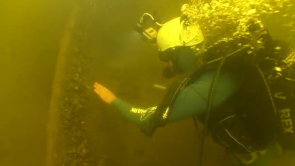 水中考古学研究 科学者のダイバーは 川の底に横たわっている18世紀の木製の船の側面を探査します — ストック動画