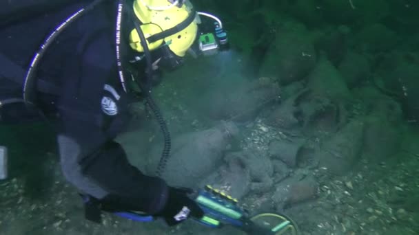 一名潜水员带着金属探测器检查位于标志着古代沉船现场的一组安布拉附近的海底 摄像机从潜水员切换到金属探测器 — 图库视频影像