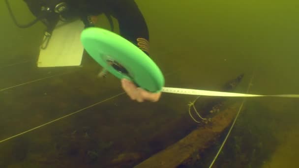 水中考古学研究 科学者のダイバーは ドニエプル川に沈んだ18世紀の木製船の計画を作成するための測定を行います — ストック動画