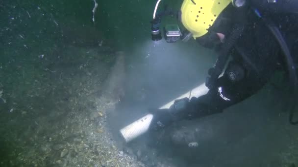 水下考古 一名研究潜水员使用液压泵吸吮水下考古现场的土壤 相机慢慢接近吸入软管 — 图库视频影像