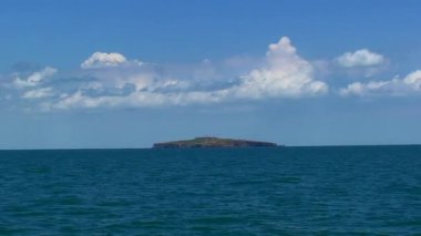 Kamera ufuktaki Yılan Adası boyunca yavaşça hareket eder, gökyüzünde hafif bulutlar. Karadeniz, Ukrayna.