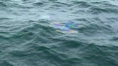 Denizin petrol kirliliği - denizin derinliklerinden çıkan dalgalı deniz yüzeyinde bir yağ tabakası. Gemi enkazı, kaza, savaş, boru hattı. Karadeniz, Ukrayna.