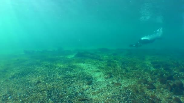 Ein Taucher Mit Einem Unterwasser Roller Macht Mehrere Umdrehungen Über — Stockvideo