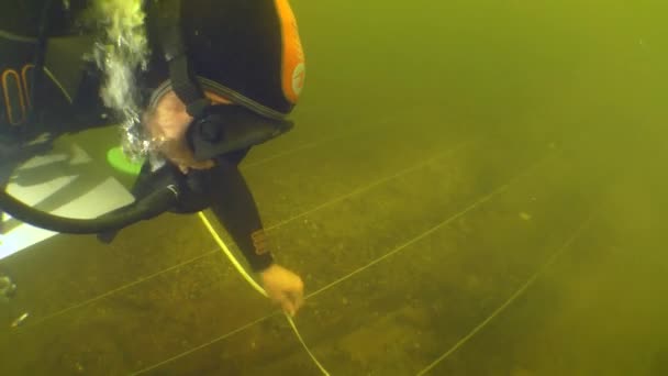 水中考古学研究 ダイバーはドニエプル川で沈没した18世紀の木製船の計画を作成するための測定を行います 上からの眺め — ストック動画