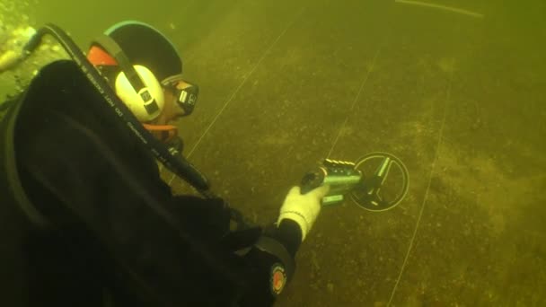 水中考古学研究 地面に隠された金属のオブジェクトを検索する研究サイトの下部にマークに沿って金属探知機とダイバー トップビュー — ストック動画