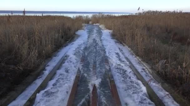 パイプから脱出した汚れた水の急速な流れは 運河を通って自然貯水池に突入します — ストック動画