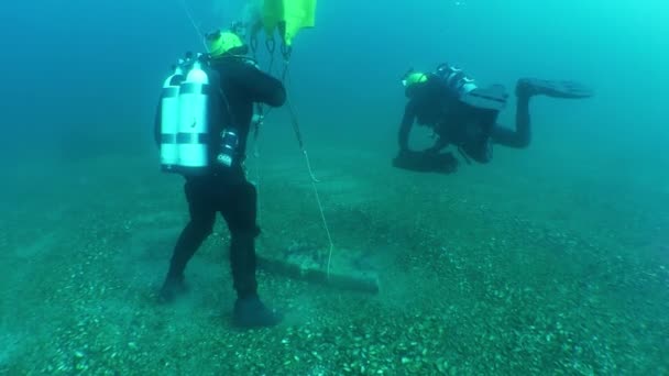 水下考古学 潜水者把装在古希腊石锚上的一袋水下提升系统充气 — 图库视频影像