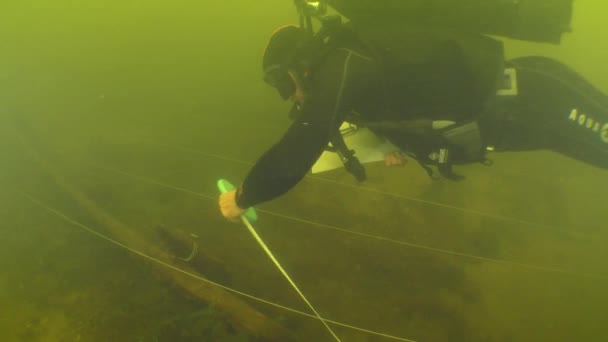 水中考古学研究 科学者のダイバーは 川の底に横たわっている18世紀の木製の船の地図を作っています — ストック動画