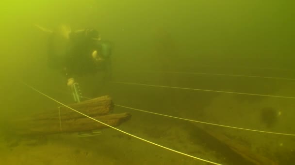 水中考古学探検 18世紀の木製船の残骸の上に金属探知機を備えた科学者ダイバーが金属オブジェクトの土壌をテストします — ストック動画