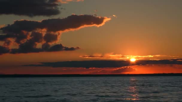 湖の上の色豊かな夕日空のタイムラプス 美しく照らされた雲 ストック映像