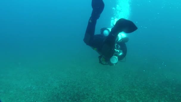 Diver with an underwater scooter moves in the water column. — Stock video