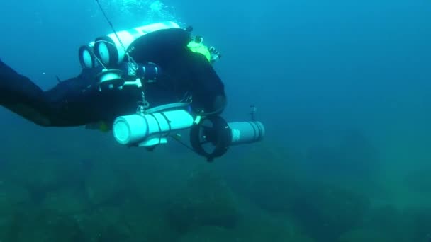 Mergulhador Técnico Com Uma Scooter Subaquática Nada Sobre Fundo Mar — Vídeo de Stock