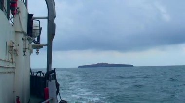 Gemi ufukta bulutlu bir havada Yılan Adası 'ndan yavaşça uzaklaşıyor. Karadeniz, Ukrayna.