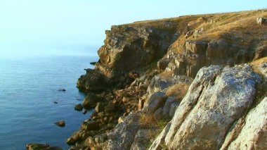 Deniz Burnu, batan güneşin ışığında Yılan Adası 'nın kayalık kıyı şeridi. Karadeniz, Ukrayna.