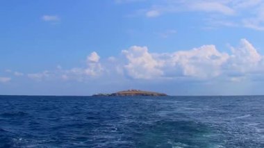 Kamera yavaşça Yılan Adası 'ndan uzaklaşır, güneşli hava, açık bulutlar, uyanma izleri. Karadeniz, Ukrayna.