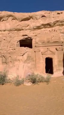 Alula, Suudi Arabistan, 4 Nisan 2024. POV 'un Hegra' daki taş mezarlarını güneşli bir günde gösteren dikey görüntüsü..    