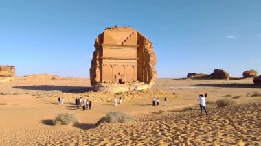 Alula, Suudi Arabistan, 4 Nisan 2024. Güneşli bir günde Hegra 'daki en büyük kaya mezarı Qar al-Fard' ın ziyaretçilerinin olduğu bir görüntü.. 