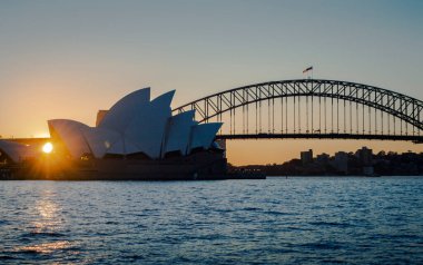 Sydney, Avustralya, 26 Temmuz 2023. Günbatımında Sydney Opera Binası ve Sydney Liman Köprüsü 'nün güzel rıhtım manzarası. 
