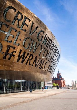 Cardiff, Birleşik Krallık, 20 Nisan 2019. Güneşli bir günde Galler Milenyum Merkezi 'nin dışı. Galce 'nin çevirisi:' İlham kaynağından cam gibi gerçek yaratmak '.