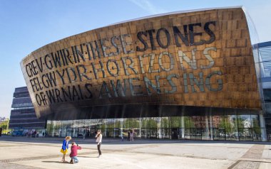 Cardiff, Birleşik Krallık, 20 Nisan 2019. Güneşli bir günde Galler Milenyum Merkezi 'nin dışı. Galce 'nin çevirisi:' İlham kaynağından cam gibi gerçek yaratmak '.