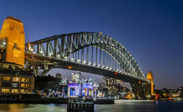 Sydney, Avustralya, 26 Temmuz 2023. Sydney Limanı Köprüsü 'nün güzel rıhtım manzarası. Geceleri renkli ışıklar.
