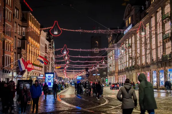 Amsterdam, Hollanda, 19 Kasım 2022. Amsterdam 'ın işlek caddesi insanlarla dolu ve kış gecelerinde renkli ışıklarla aydınlanıyor..