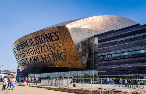 Cardiff, Birleşik Krallık, 20 Nisan 2019. Güneşli bir günde Galler Milenyum Merkezi 'nin dışı. Galce 'nin çevirisi:' İlham kaynağından cam gibi gerçek yaratmak '.