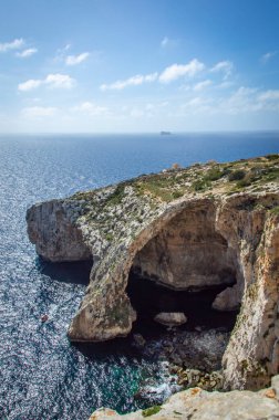 Güneşli bir günde Malta Blue Grotto 'da fotoğraf çeken bir erkek ziyaretçinin arka görüntüsü. 