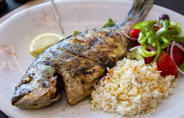 Yunanistan 'da yerel bir restorandan pirinç ve salata ile ızgara deniz çamı